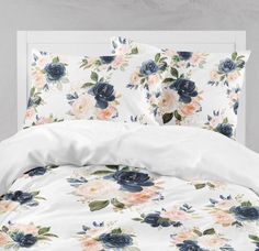 a white bed with blue and pink flowers on it