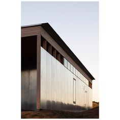 the side of a building that is made out of wood and metal with windows on it