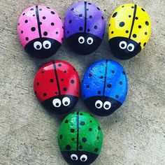 six painted ladybugs sitting on top of a cement floor next to each other