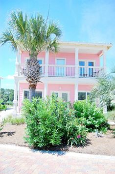 a pink house with palm trees in front of it