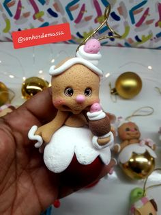 a hand is holding a small doll ornament