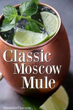 a moscow mule in a copper mug with limes and mint garnish on the rim