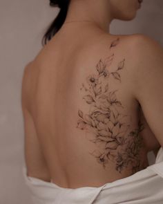 the back of a woman's shoulder with flowers on it