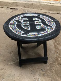 a black table with the letter b painted on it's side in front of a building