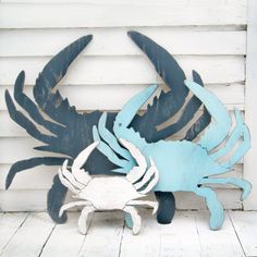 two blue and white crab sculptures sitting on top of a wooden floor