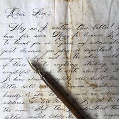 an old manuscript with writing on it and a fountain pen resting on the top one