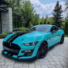 a blue mustang parked in front of a house