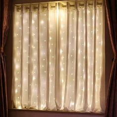 the lights are shining on the curtains in the window sill, which is lit up