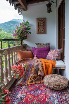 a balcony with colorful pillows and rugs on it