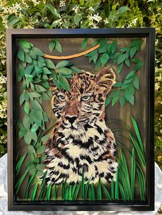 a painting of a tiger sitting on top of green grass next to some bushes and trees