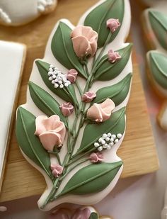 decorated cookies with pink flowers and green leaves