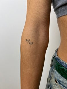 a woman's arm with a small tattoo on the left side of her body