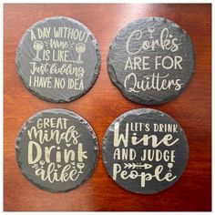 four slate coasters with different sayings on them sitting on top of a wooden table