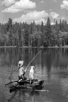 a boy and his dog are fishing in the lake