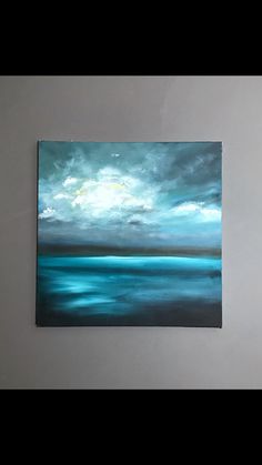 a painting hanging on the wall in a room with white walls and blue ocean waves