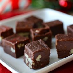 several pieces of chocolate dessert on a white plate next to a christmas ornament