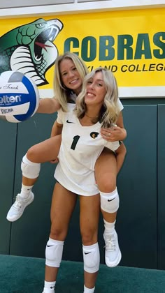 two female volleyball players are posing for a photo