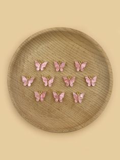 six pink butterflies on a wooden plate with gold studs in the shape of hearts