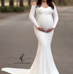 a pregnant woman in a white gown standing on the street