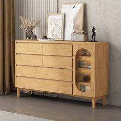 a wooden dresser sitting next to a wall with pictures on it's sideboard