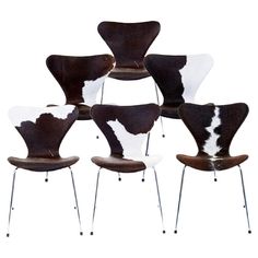 six chairs with cow hide upholstered on the back and legs, all in different colors