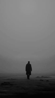 a person walking on the beach in the fog