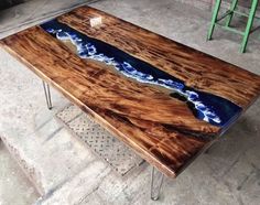 a table made out of wood and metal legs with blue paint on it's surface