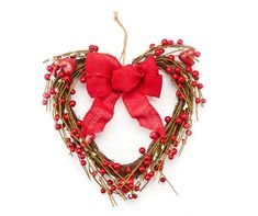 a heart shaped wreath with red berries and a bow hanging from the front on a white background