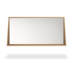 a wooden frame mirror on a white wall