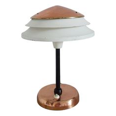 a white and gold lamp with a black base