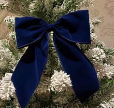 a blue bow on top of a christmas tree