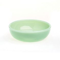 a green bowl sitting on top of a white table