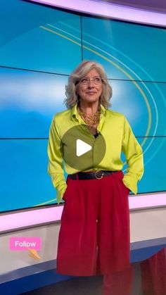 an older woman is standing in front of a news set with her hands on her hips