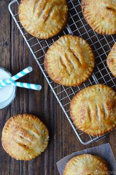 several pastries on a cooling rack next to a glass of milk