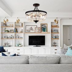 a living room filled with furniture and a flat screen tv on top of a wooden shelf