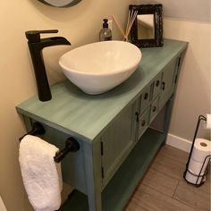 a bathroom sink sitting on top of a green cabinet