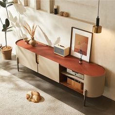 a living room with an entertainment center and potted plants on the sideboard in front of it