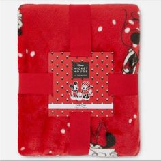 a red blanket with mickey and minnie mouses on it, folded up to the side