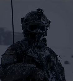 a soldier in the snow holding an umbrella and looking at something while standing next to him