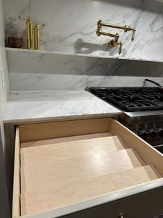 a kitchen with marble counter tops and gold faucets on the wall above an oven