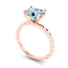 a rose gold engagement ring with an aqua blue topazte stone in the center