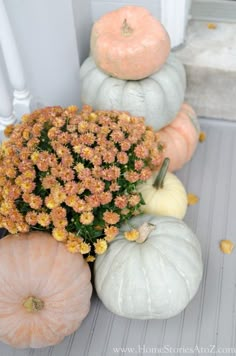 several pumpkins and flowers on the front porch