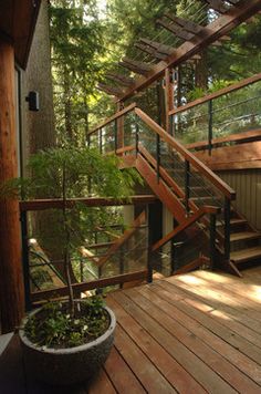 there is a wooden staircase going up to the top floor in this house with glass balconies