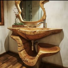 a bathroom sink made out of wood with a wooden bench underneath it and a mirror on the wall