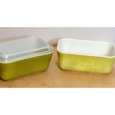 two green and white dishes sitting on top of a wooden table next to each other