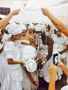 a group of people dressed in white taking pictures