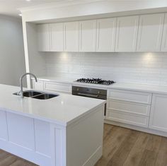 a kitchen with white cabinets and an island