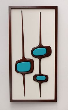 an art piece with blue and brown shapes on it's sides, hanging on a wall