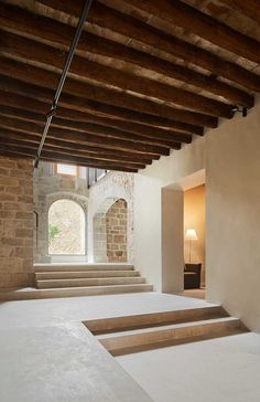 an empty room with stone steps leading up to the second floor