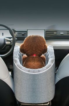 a teddy bear is sitting in the center console of a car seat with its head on the steering wheel